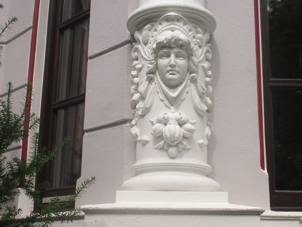 Restaurierte Stucksäule mit Frauenkopf an einer Gründerzeitfassade